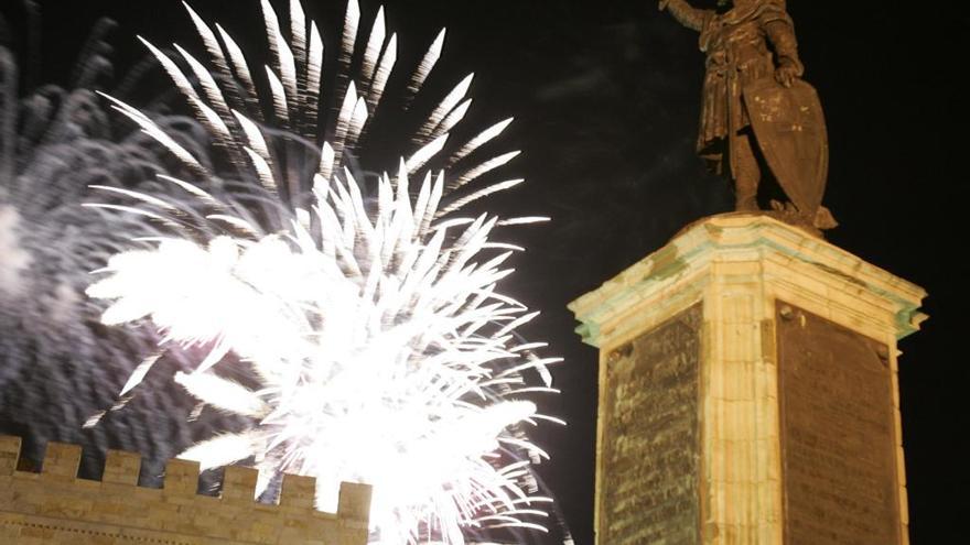 La estatua de Pelayo de la plaza del Marqués con fuegos artificiales de la fiesta de Begoña al fondo.