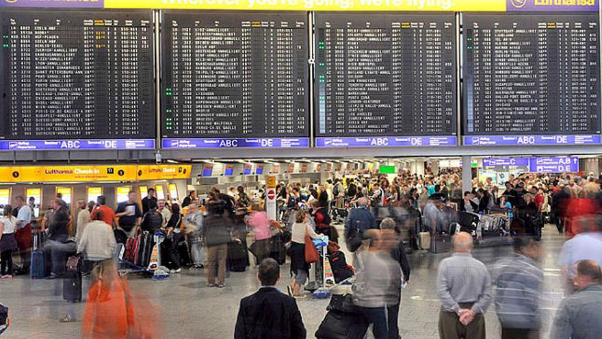 Els viatgers observen un panell informatiu a l&#039;aeroport de Frankfurt.