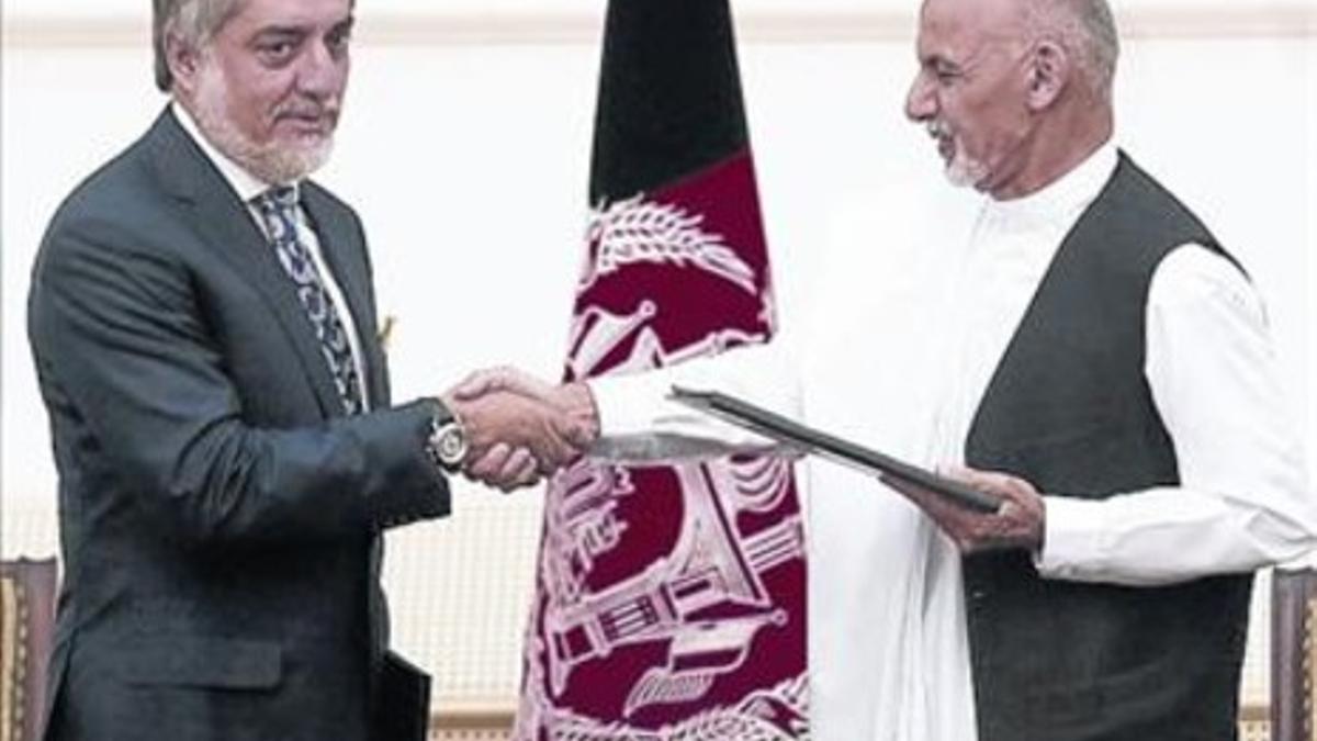 Ghani (derecha) y Abdulá se dan la mano tras firmar el acuerdo, este domingo.