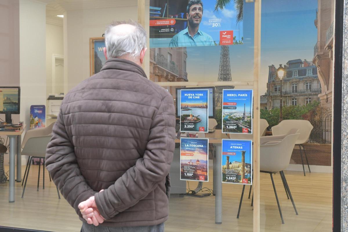 Un hombre mira el escaparate de una agencia de viajes en A Coruña este martes