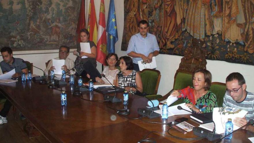 Tomás del Bien, de pie, rodeado de los concejales del PSOE se dispone a tomar asiento en un pleno. Foto