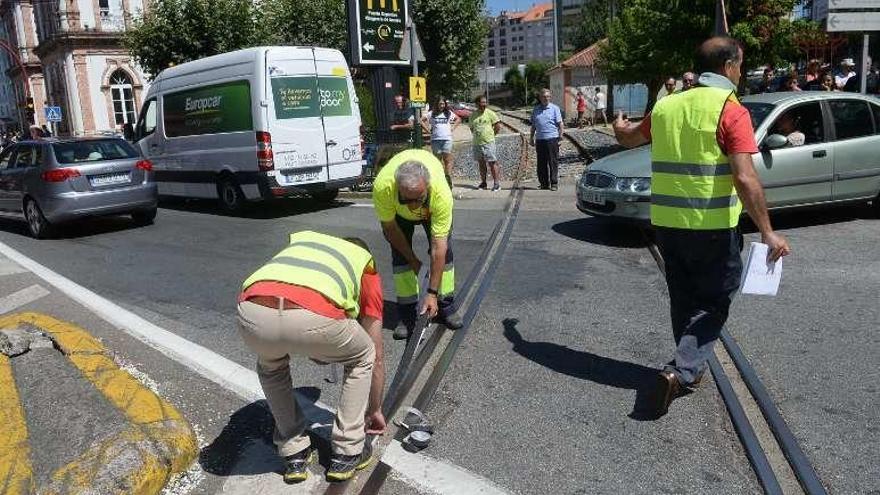 Operarios retocan la carretera antes del paso de los ciclistas. // N. P.