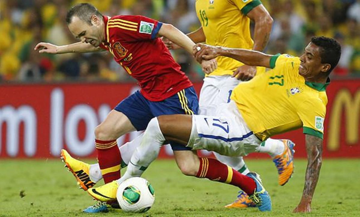 Iniesta intenta desfer-se de Luiz Gustavo.
