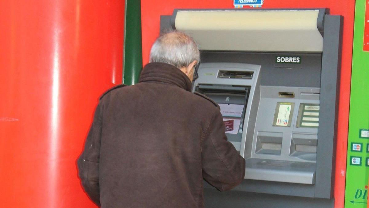 Un cliente saca dinero de un cajero automático.