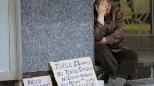 Un hombre pide dinero en la calle. 