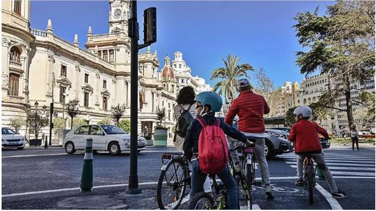 Una familia recorre en bicicleta el centro de València.