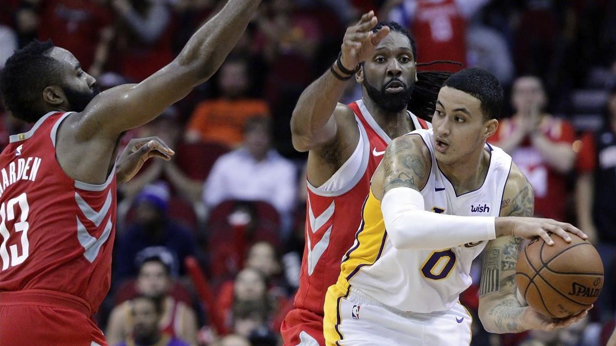 Kyle Kuzma intenta pasar el balón bajo la presión de James Harden y Nene Hilario