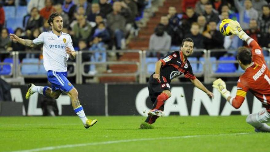 Bruno supera a Roberto en el primer gol de los blanquiazules ayer en La Romareda. / lof