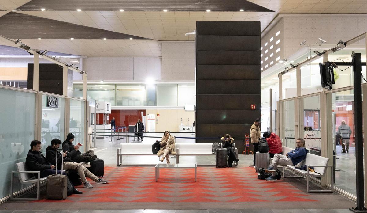 Varios pasajeros esperan en una de las salas de la estación Delicias.