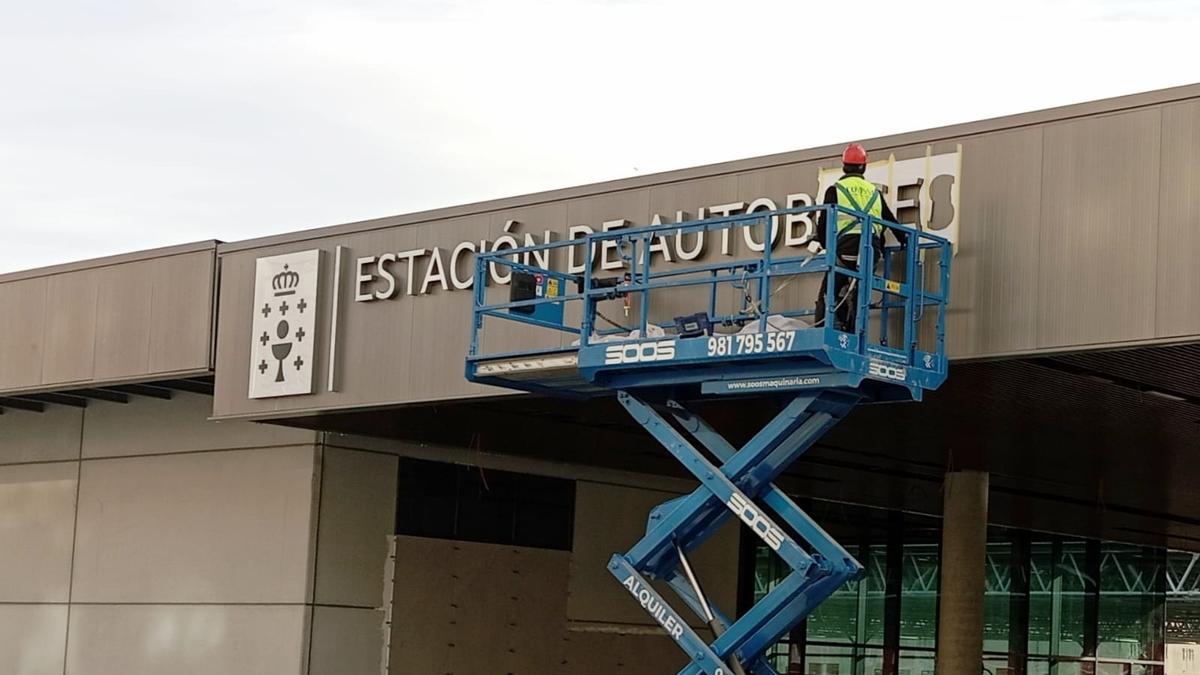 Los operarios colocan el cartel de la nueva estación de autobuses