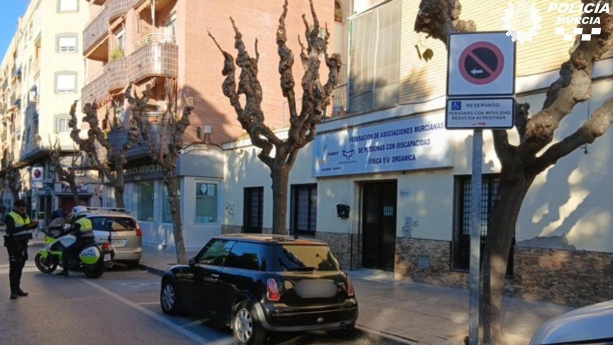 Agentes de la Policía Local de Murcia multan a un vehículo aparcado en zona de minusválidos.