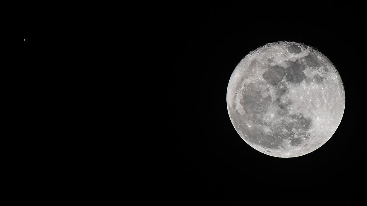 Marte, visible en el extremo superior izquierdo de la imagen, junto a la luna llena, el 2 de agosto en Ciudad de Panamá.