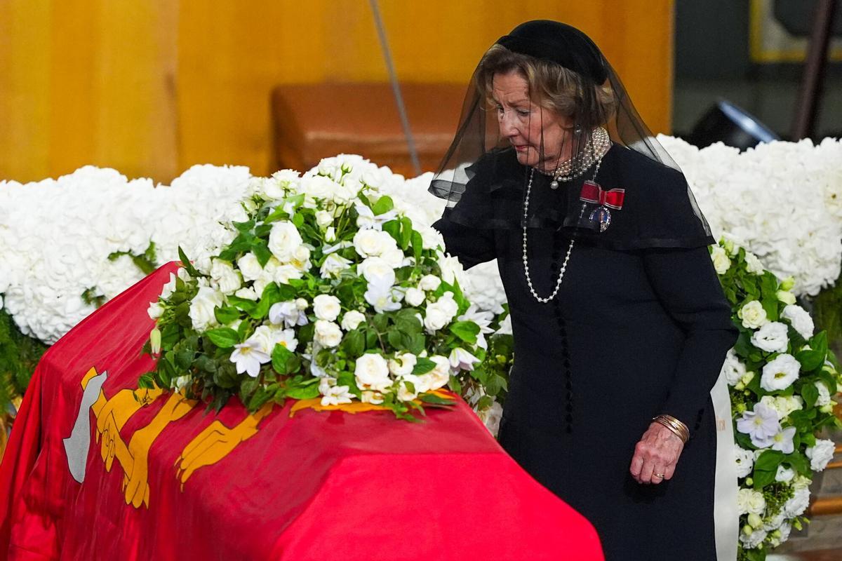 La reina Sonja de Noruega deposita una rosa sobre el féretro.