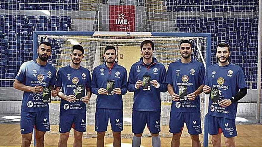 Parte de la plantilla del Palma Futsal posa con el programa.