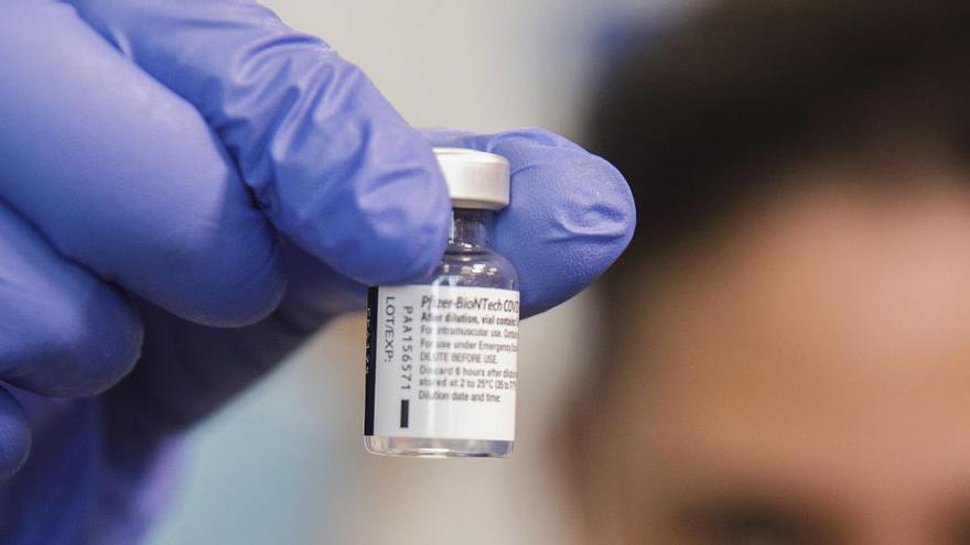 Una enfermera sostiene una dosis de la vacuna de Pfizer