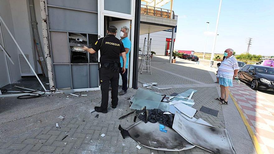 Un vigilante explica los daños en el cajero reventado en Santa Pola.