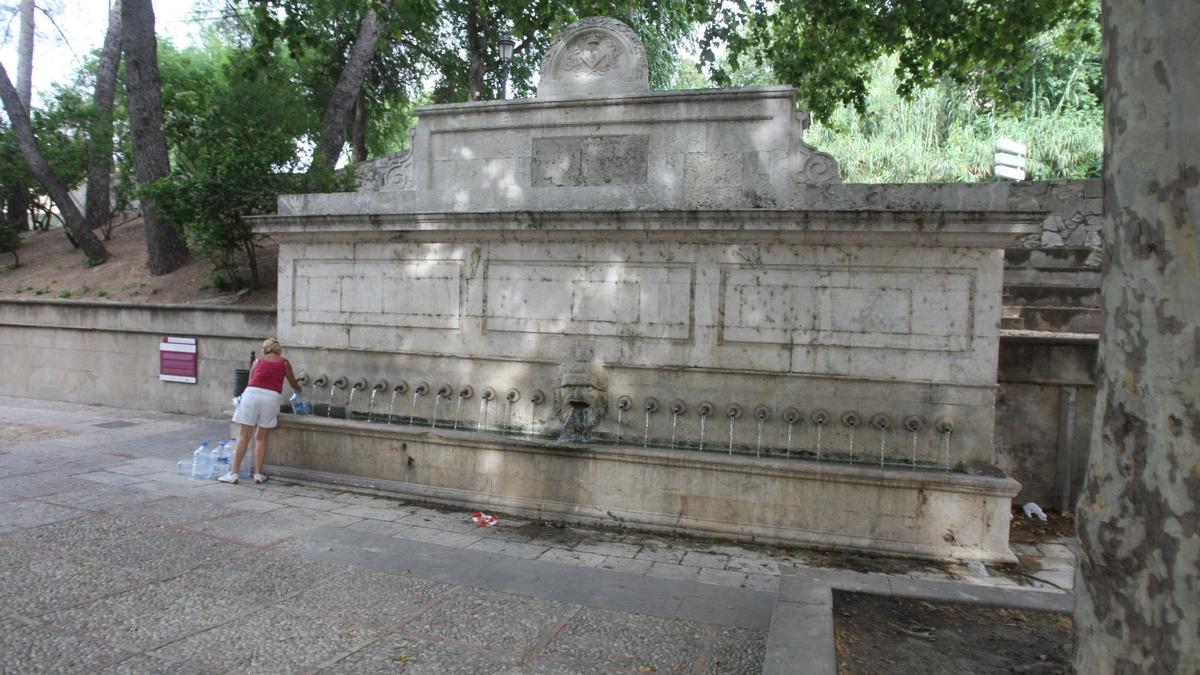 Una mujer llenando unas botellas en la fuente de los 25 chorros de Xàtiva, en una imagen de archivo.