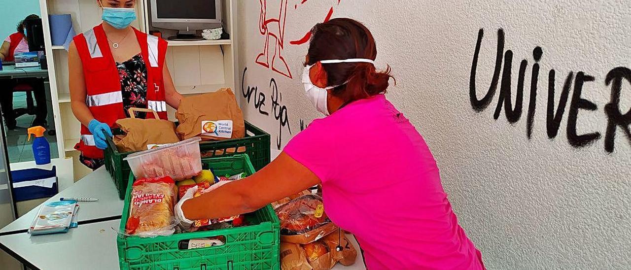 Una usuaria recoge los alimentos, ayer, en la sede de Cruz Roja en Paiporta.