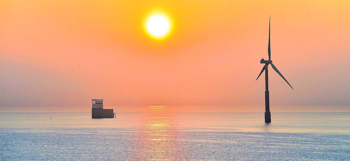 Vista del sol al amanecer, entre la plataforma del PLOCAN y el aerogenerador marino situado en la costa de Jinámar y Las Palmas de Gran Canaria.