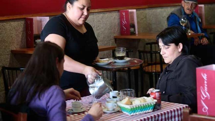 Una camarera atiende a dos clientas en un bar de Vigo. // Adrián Irago