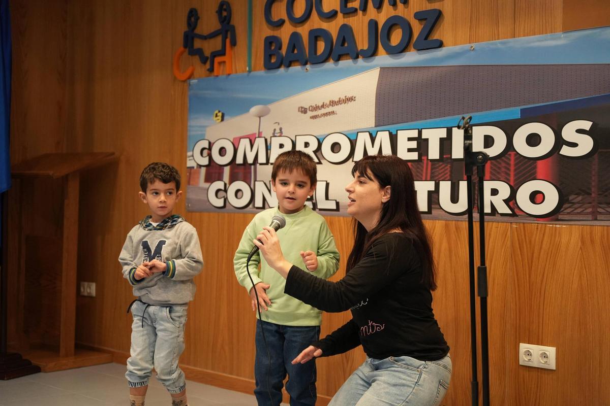 Dos de los niños que participan en el taller de canto junto a la profesora.