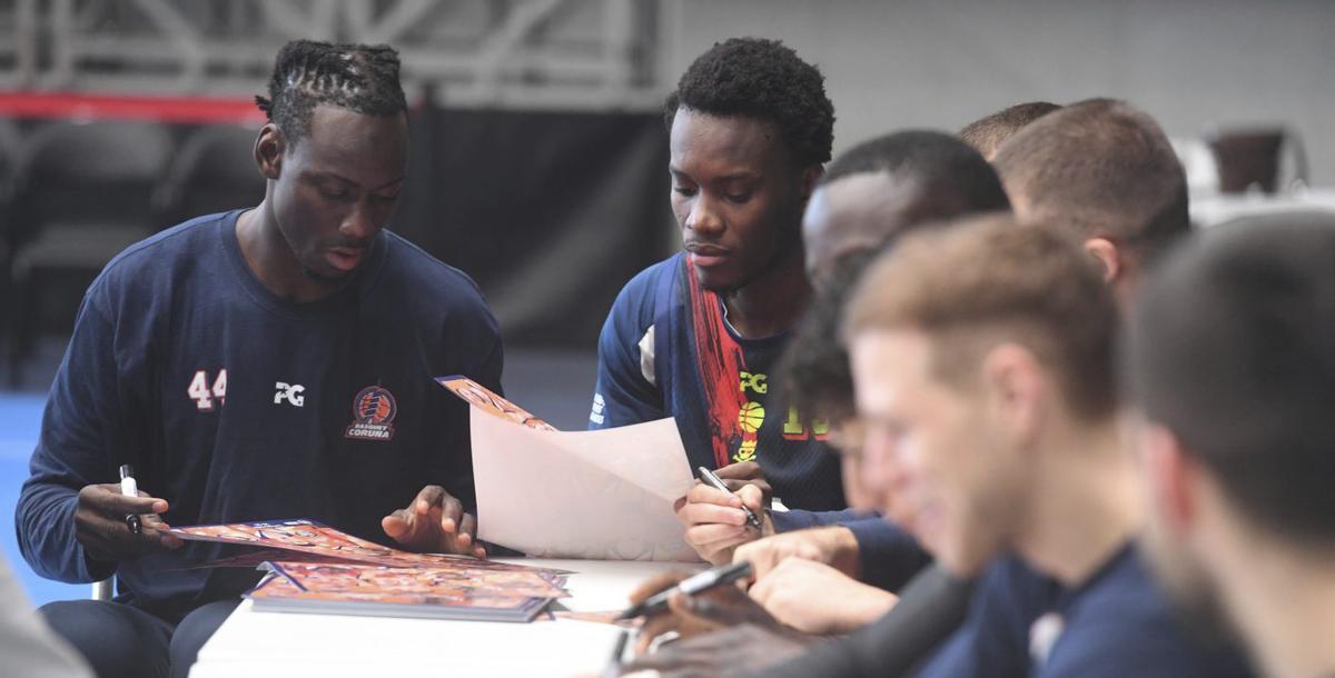 La plantilla del Leyma firma pósteres durante un encuentro con los jugadores de la base. |  C. Pardellas