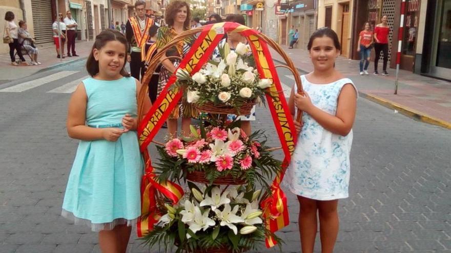Dos niñas con unas flores de la Cofradía de la Patrona de Jumilla.