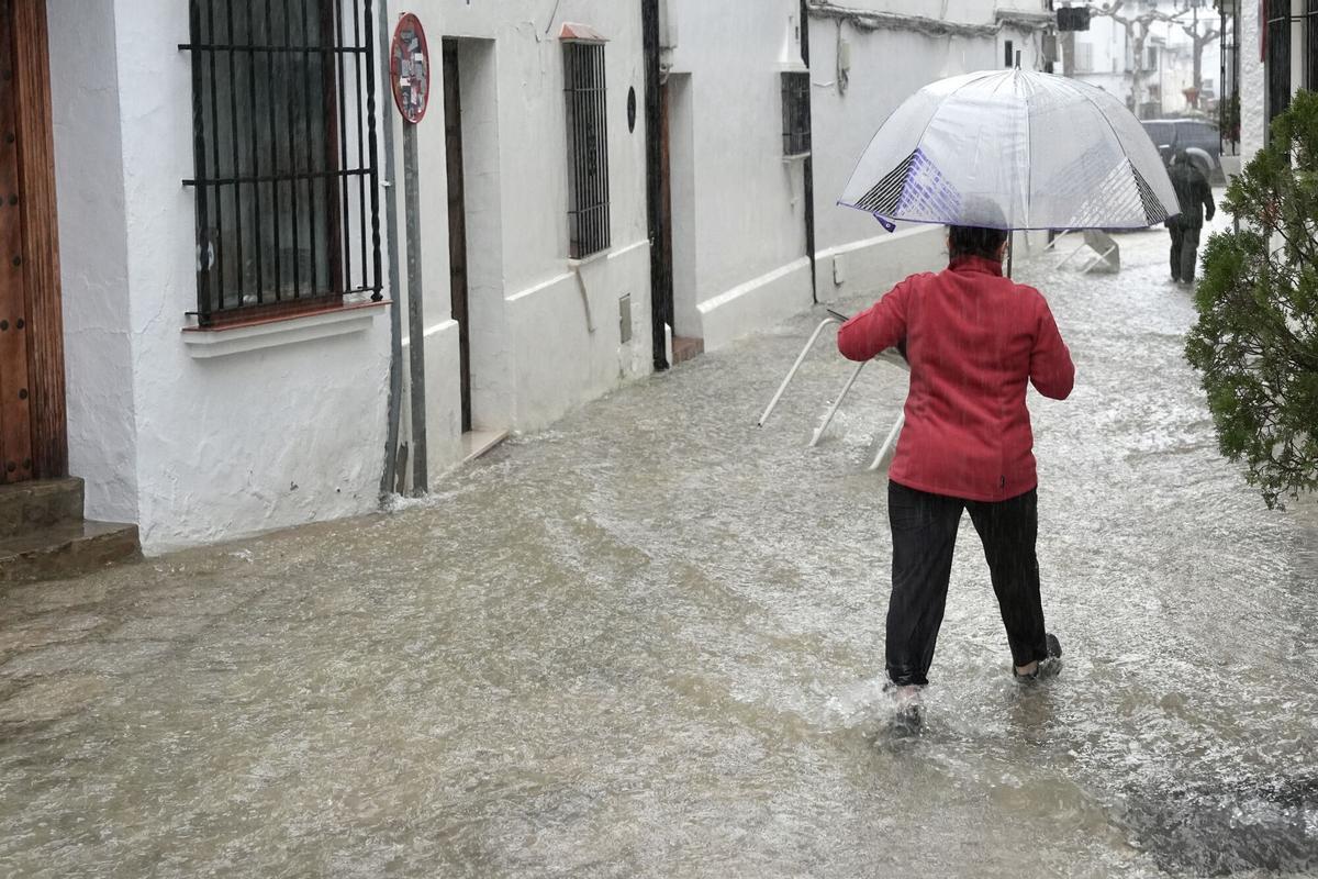 Una vecina de Grazalema pasa por una calle inundada