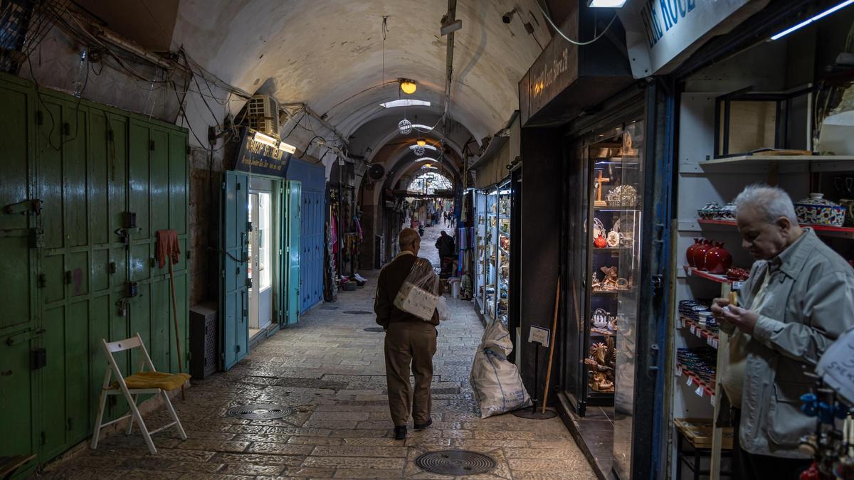 Un hombre pasea por una calle comercial de Jerusalén.