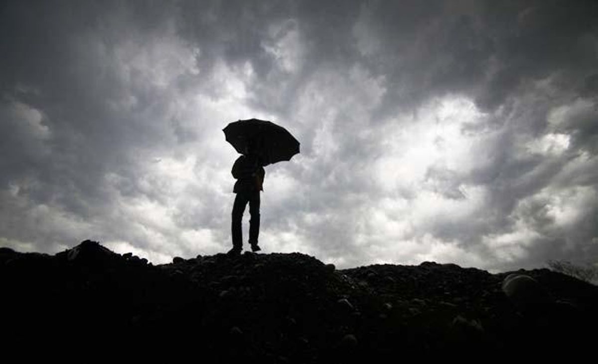 Un noi es protegeix de la pluja amb un paraigua a Jammu, Índia.