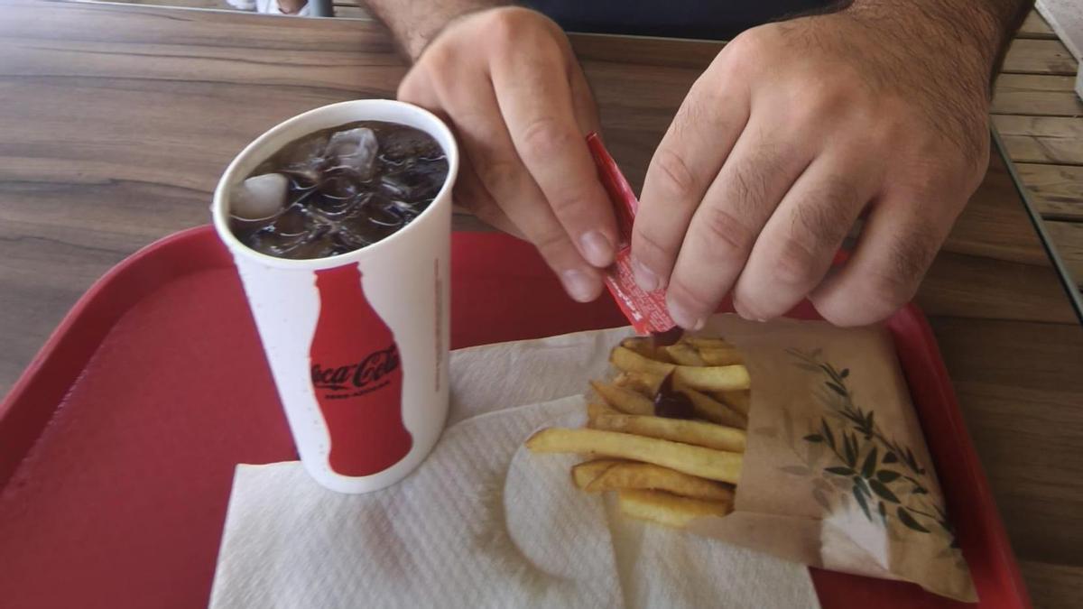 Un hombre con un sobre de kétchup en un restaurante de Castellón.