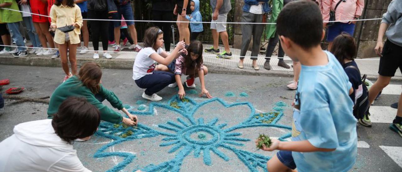 Alumnos de la Escuela de Arte elaboran su propio tapiz, ayer, en una calle de Ponteareas.  // ANXO GUTIÉRREZ