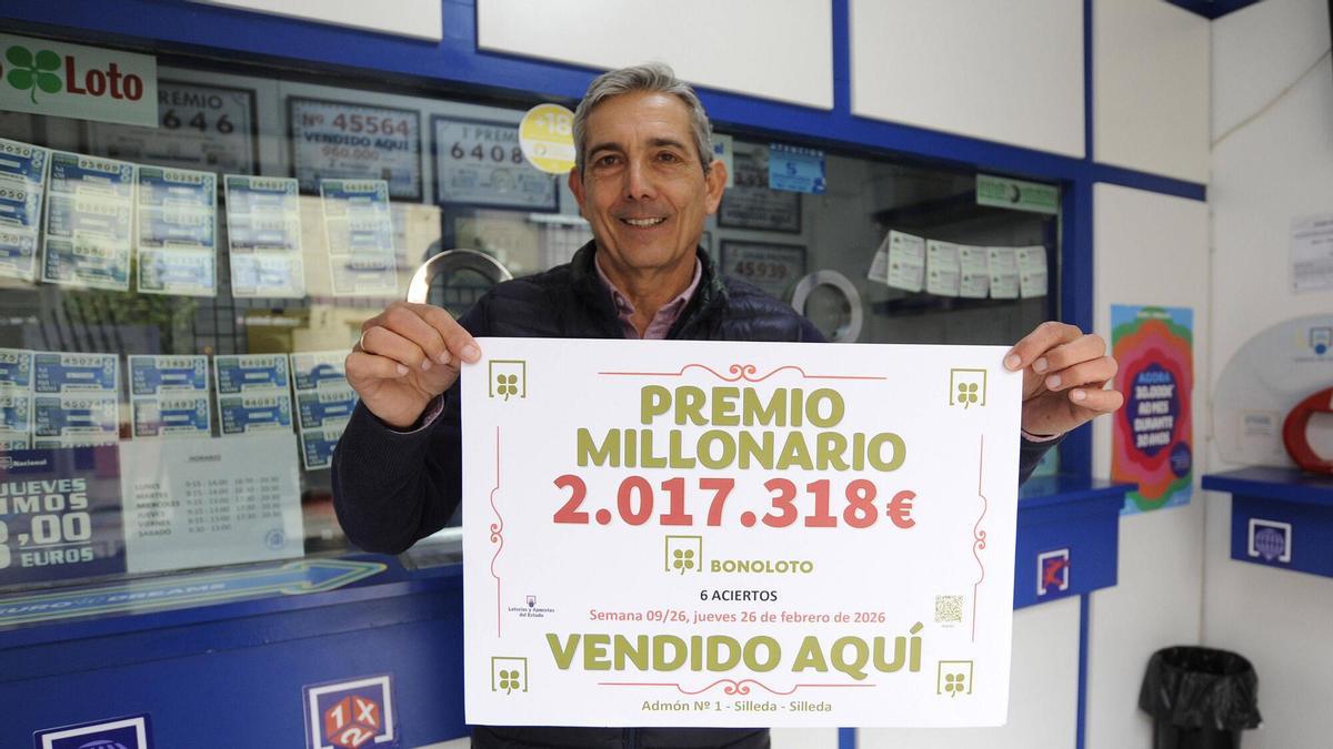 El propietario de la Administración de Lotería de Silleda posa con un anterior premio de Bonoloto que recayó en su local.