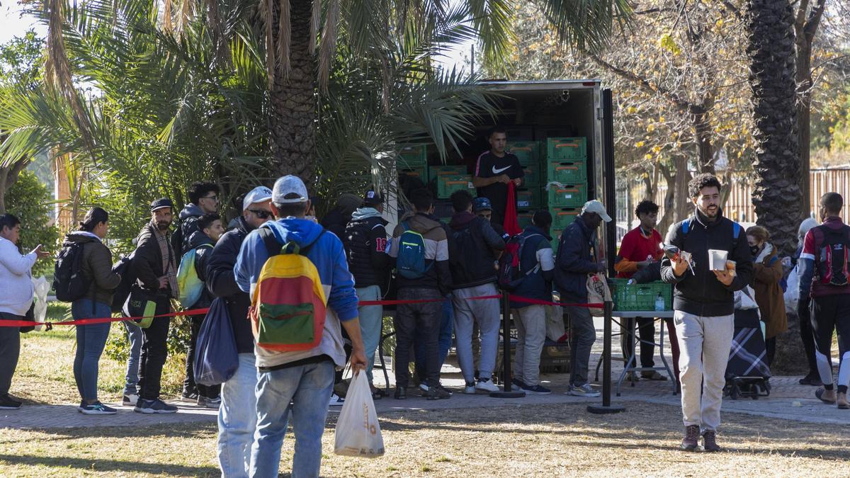 Cola de personas vulnerables para recoger comida en el cauce del Turia.