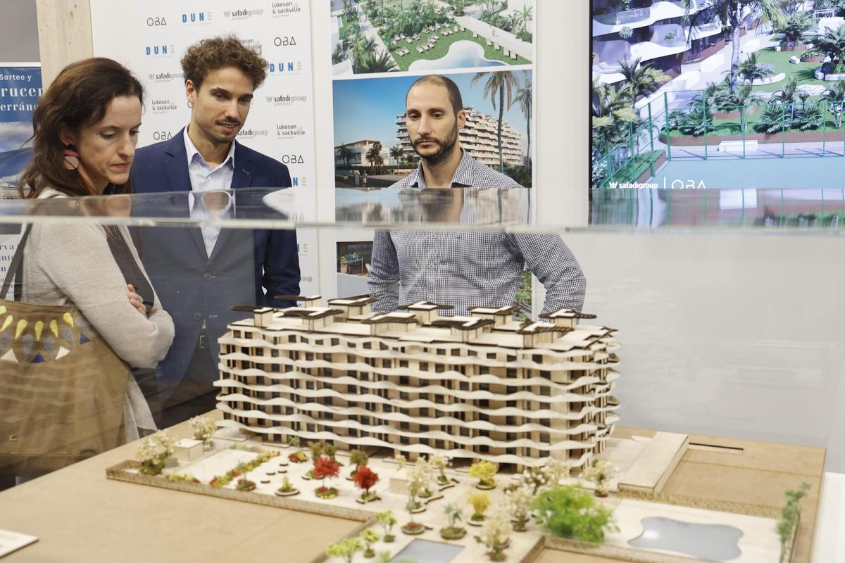 Una pareja, interesada en comprar una casa, observa la maqueta de un nuevo bloque de edificios en València.