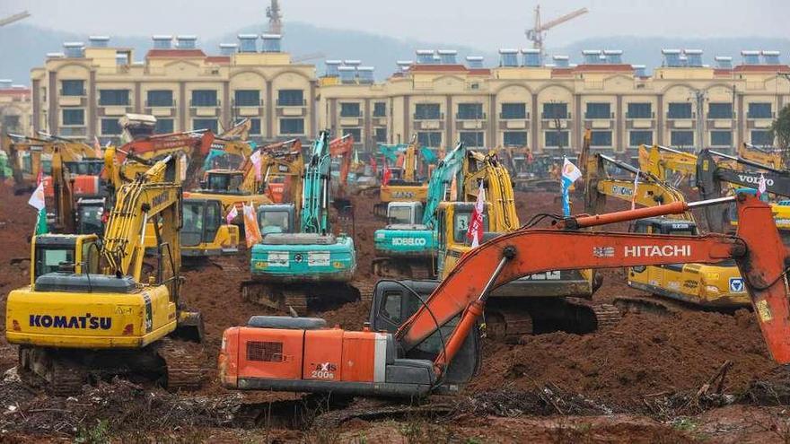 Decenas de excavadoras preparan el terreno para construir el nuevo hospital de Wuhan y contener la epidemia. // Efe