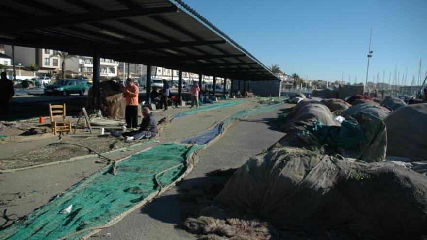 Pescadores arreglando algunas de las redes en el puerto.