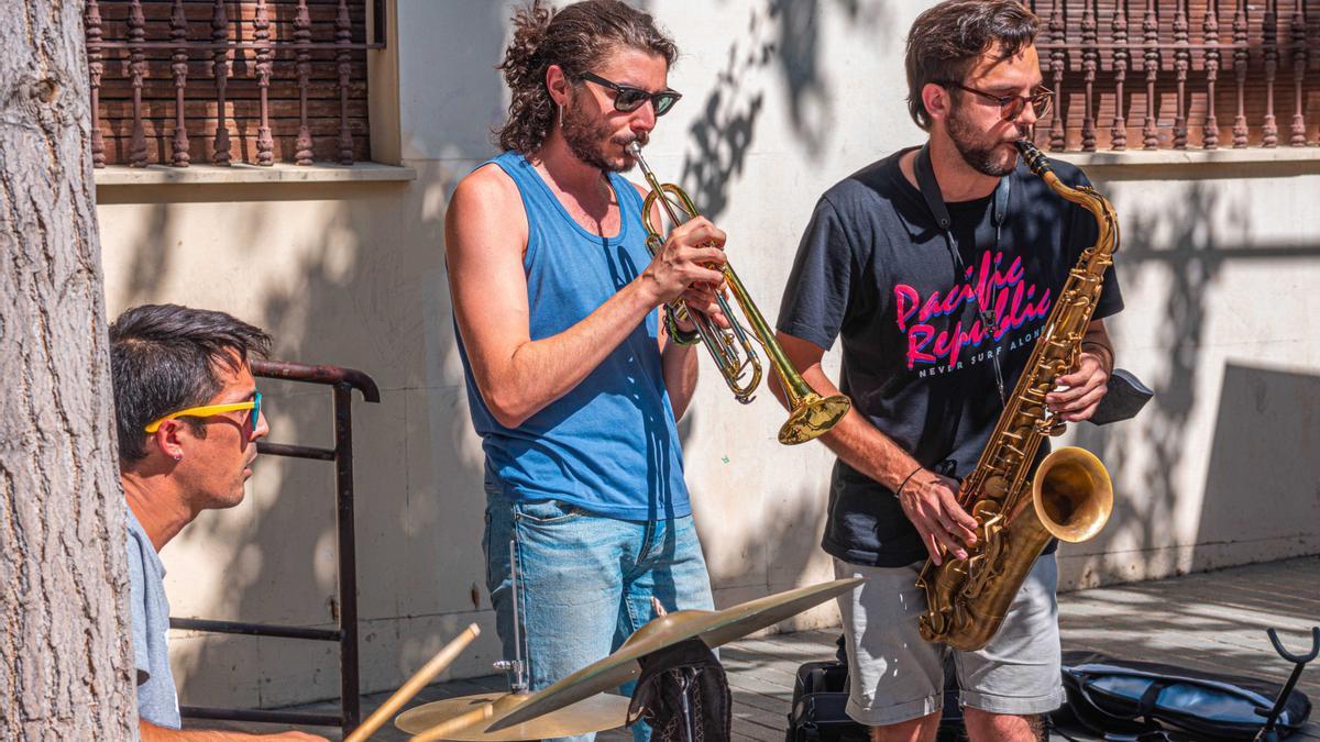Tres músicos ofrecen un concierto en la calle.