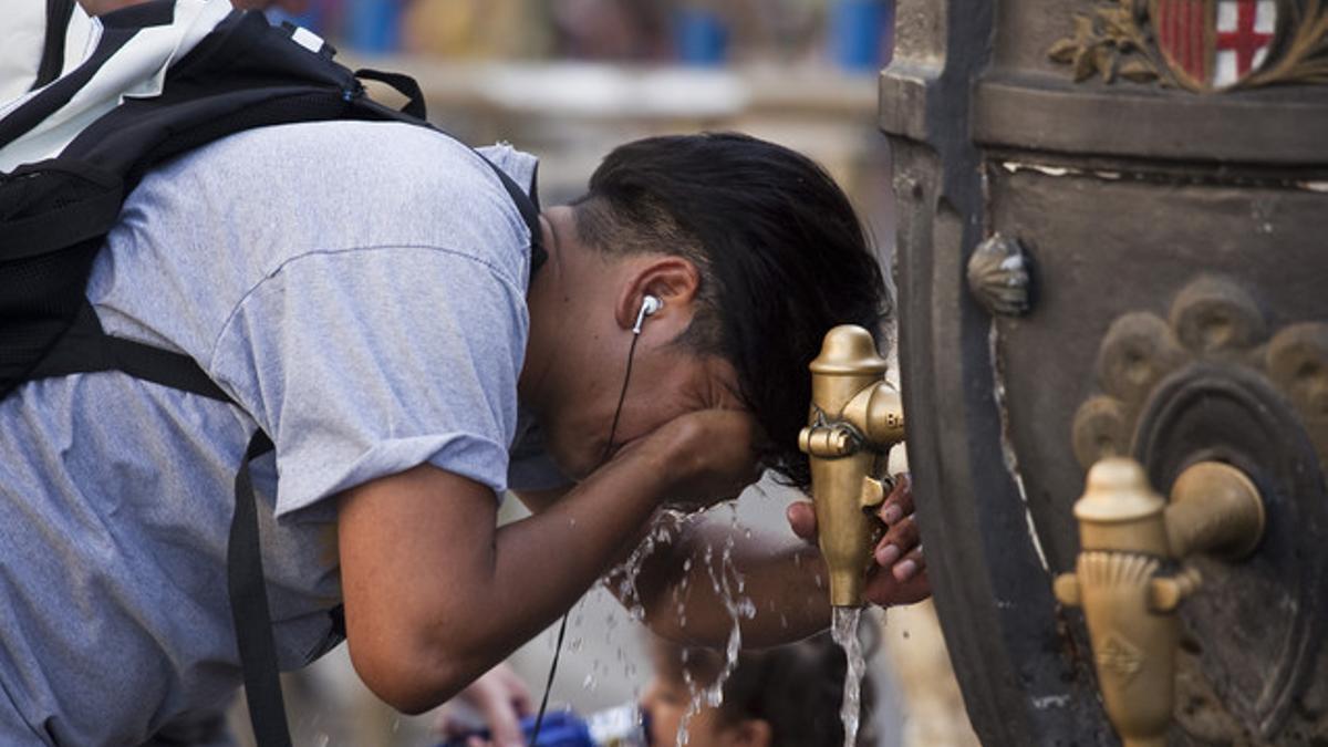 Un turista se refresca en la fuente de Canaletes durante la ola de calor de los últimos días.