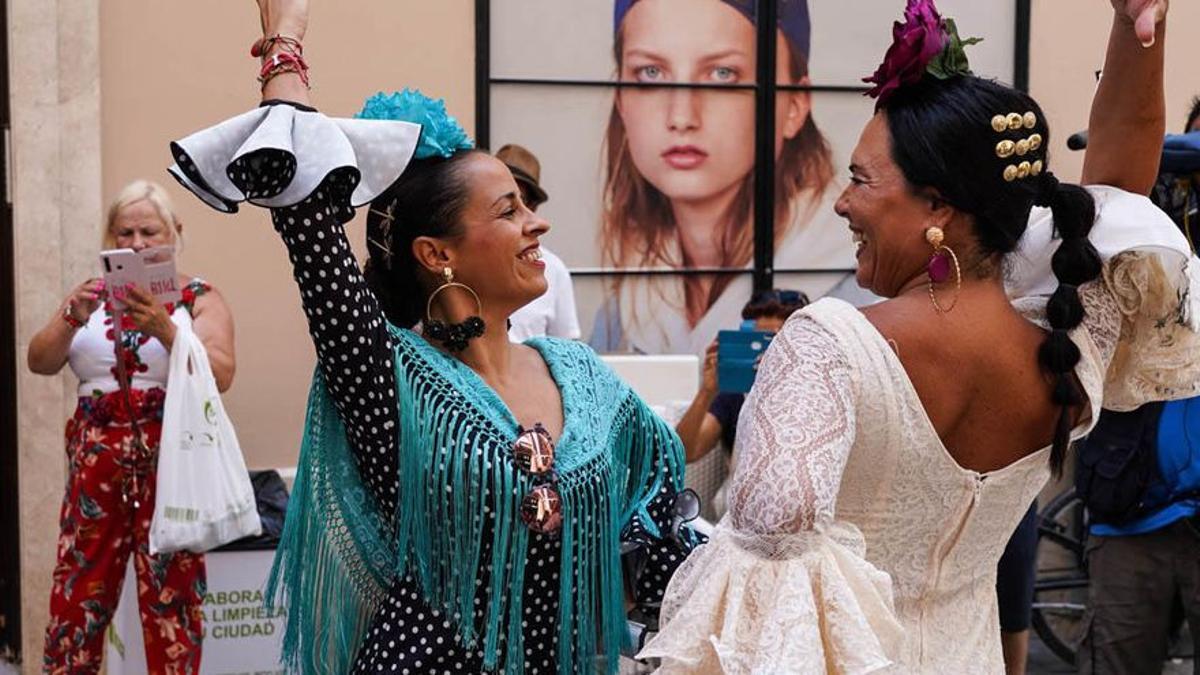 Dos mujeres bailan en la Feria de Málaga de 2019.