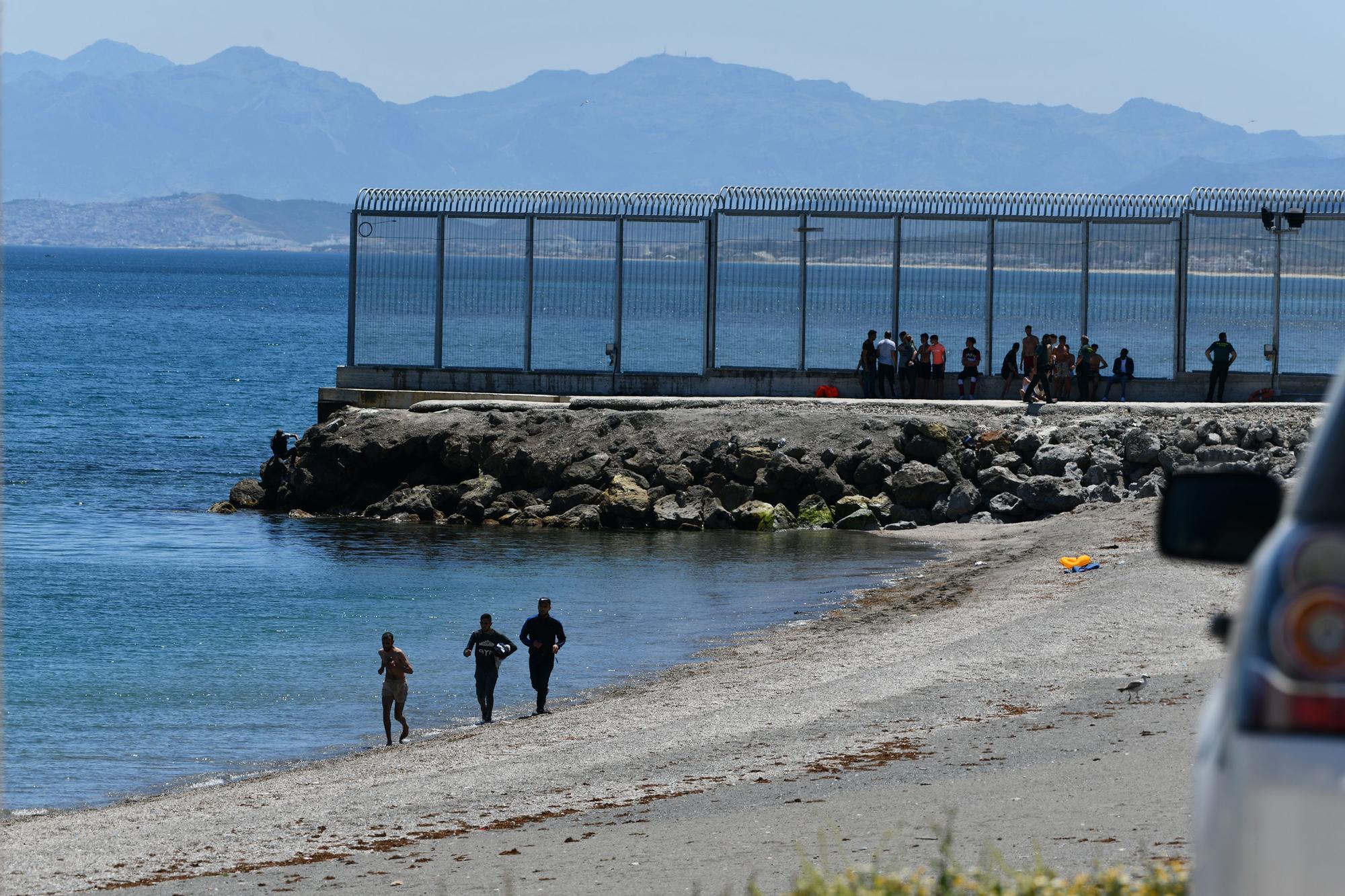 Migrantes que cruzan la frontera a nado en Ceuta sorteando los espigones en una imagen de julio de 2021.
