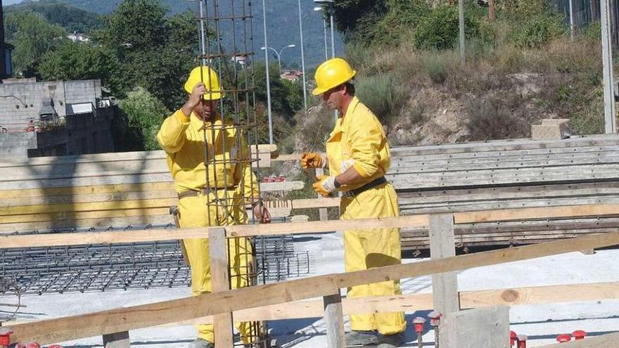 Dos obreros de la construcción se afanan en los trabajos de un edificio en la ciudad. // Iñaki Osorio