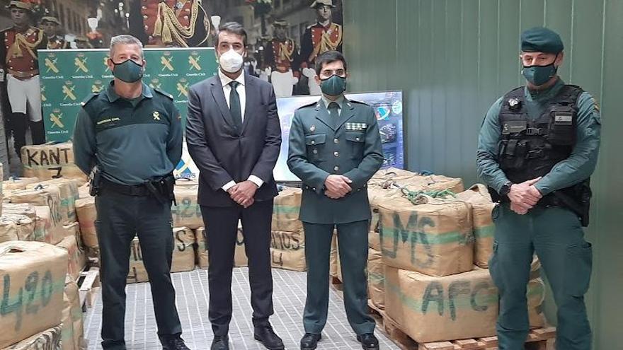 El delegado de la Agencia Tributaria en Baleares, Carlos González, y el comandantes y agentes de la Guardia Civil con los fardos de hachís.
