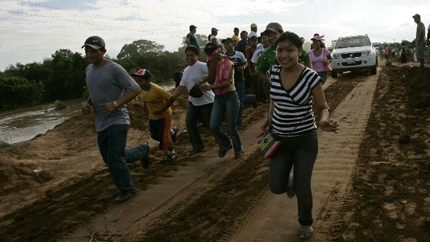 Pobladores en el Oriente de Santa Cruz, cruzan este, 31 de enero de 2008, un puente entre la caretera de Santa Cruz y Beni en el oriente boliviano. Bolivia sufre este año los efectos del fenómeno climático de &quot;La Niña&quot; con lluvias, inundaciones y riadas que han causado ya al menos 45 muertos, cuatro desaparecidos y unas 30.000 familias damnificadas, según cifras oficiales difundidas hoy, 01 de febrero de 2008. Si entre enero y marzo de 2007 fue &quot;El Niño&quot; el que provocó 56 muertos, 600.000 afectados y unas pérdidas de 443,3 millones de dólares, un cuatro por ciento del Producto Interior Bruto (PIB); del país, este año es &quot;La Niña&quot; la que golpea con fuerza a Bolivia, la nación más pobre de Suramérica.