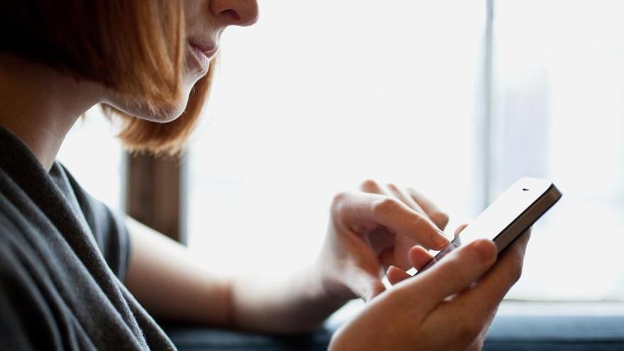 Una mujer utiliza un teléfono móvil.