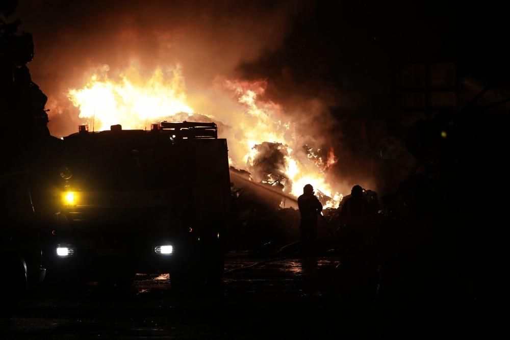 Labores de extinción del incendio de un desguace en Gijón