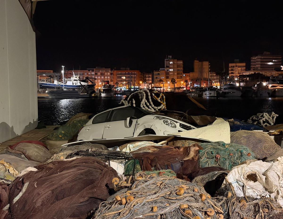 El coche afectado por la tromba marina junto a unas redes en el puerto pesquero de Mazarrón.