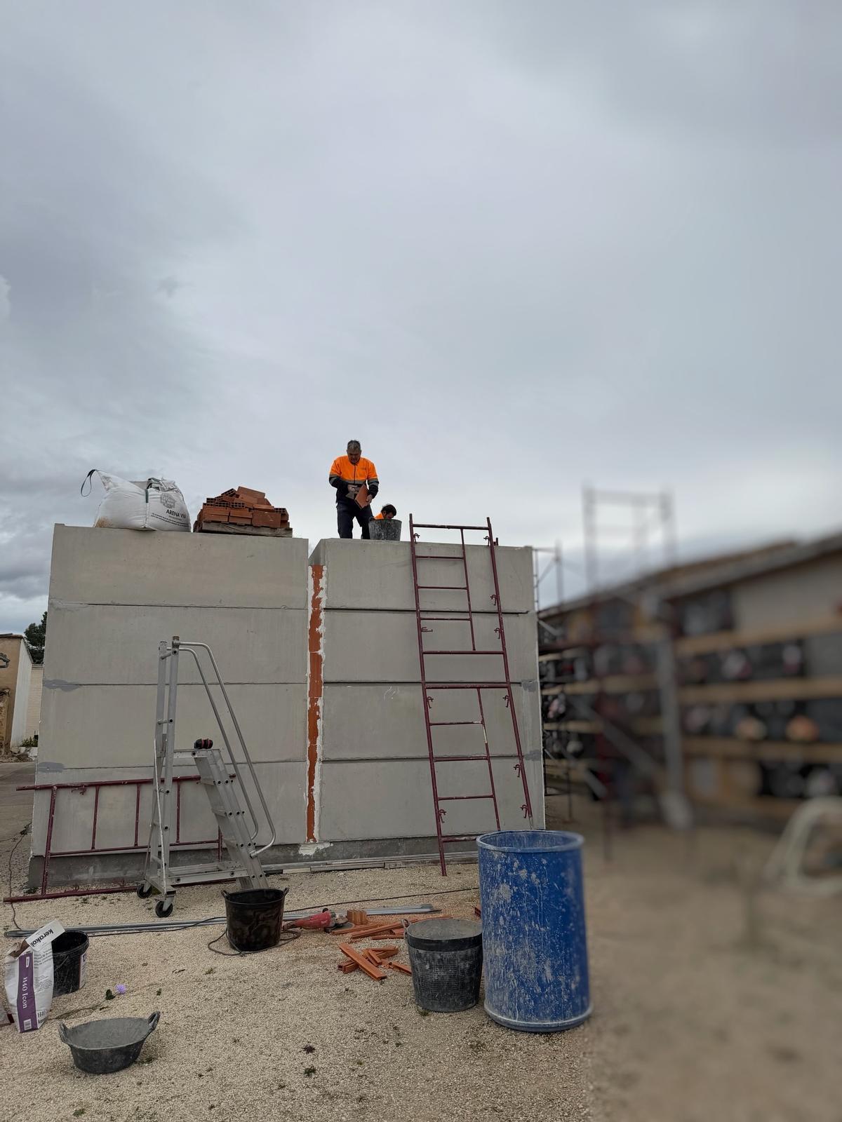 Operarios trabajando en las obras de construcción de nichos en el cementerio de Albaida.