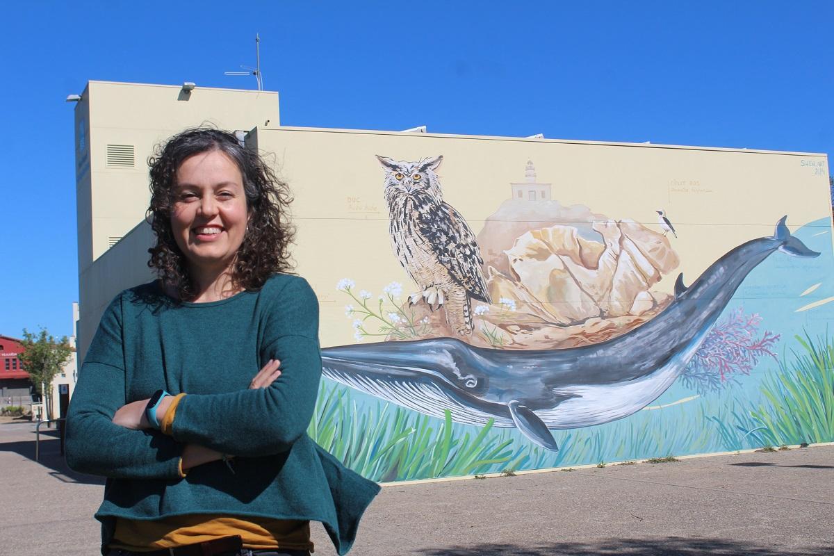 Montse Pascual davant del mural de la seu del Parc Natural de Cap de Creus a Vilajuïga.