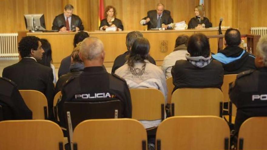 Los nueve procesados, ayer, sentados en la Audiencia y custodiados por policías. / 13fotos